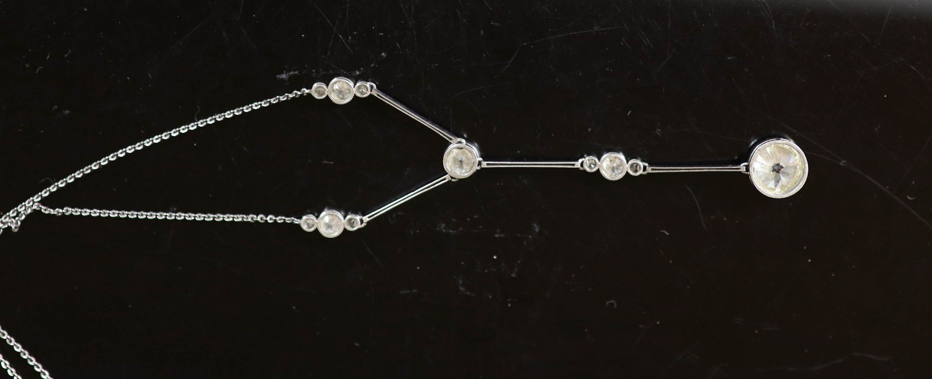A 1920's platinum and eleven stone diamond set drop pendant necklace